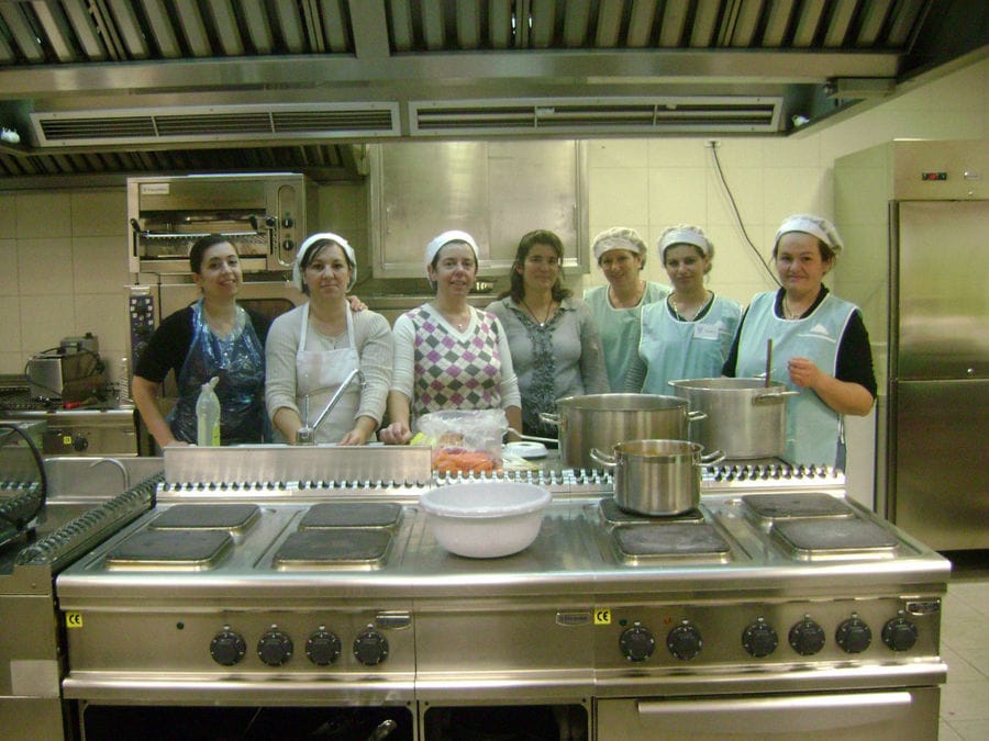 women standing back on the kitchen and smiling at the camera at workshop